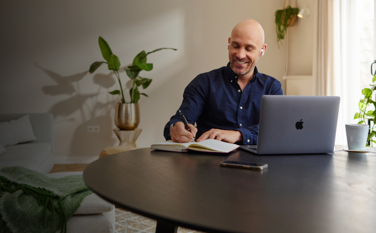 Man met laptop en notitieblok